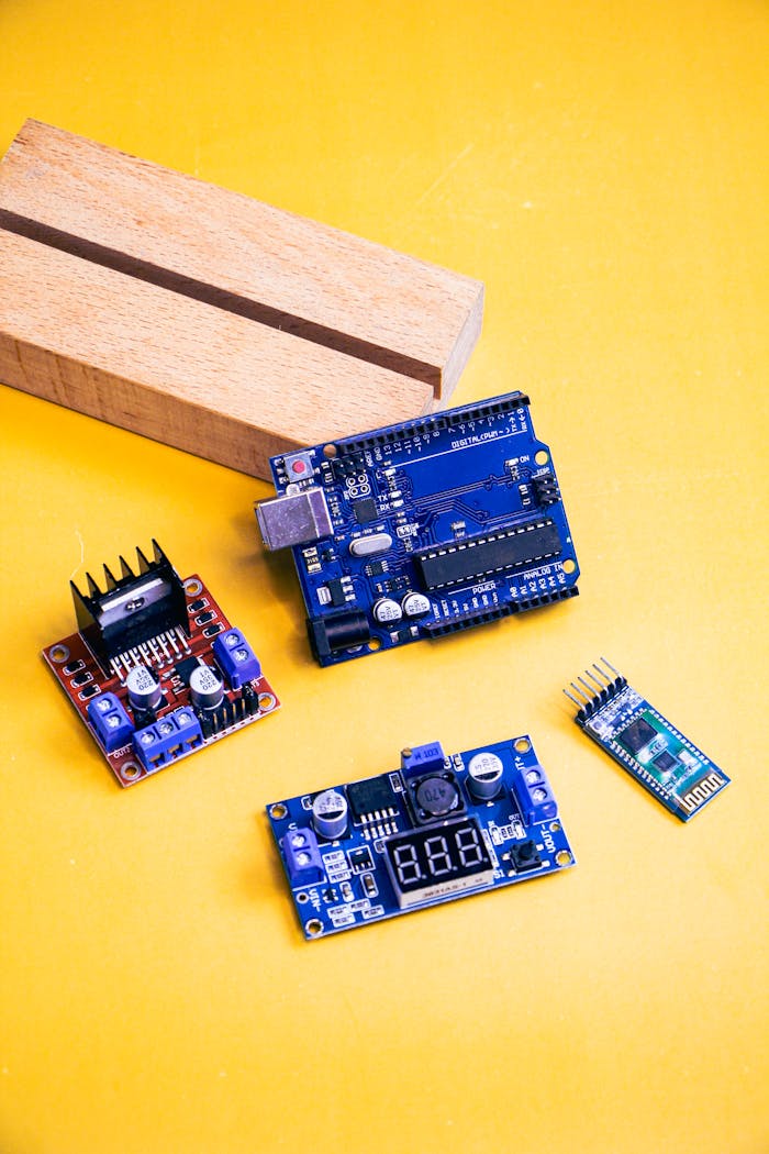 A collection of electronic components arranged on a vibrant yellow surface for a tech-inspired photoshoot.